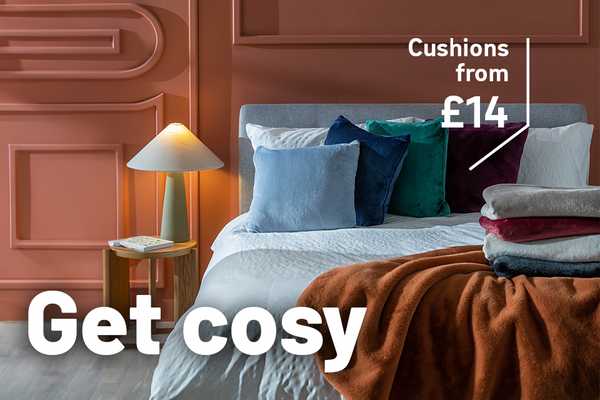 Double bed with a variety of faux fur cushions and throws.
